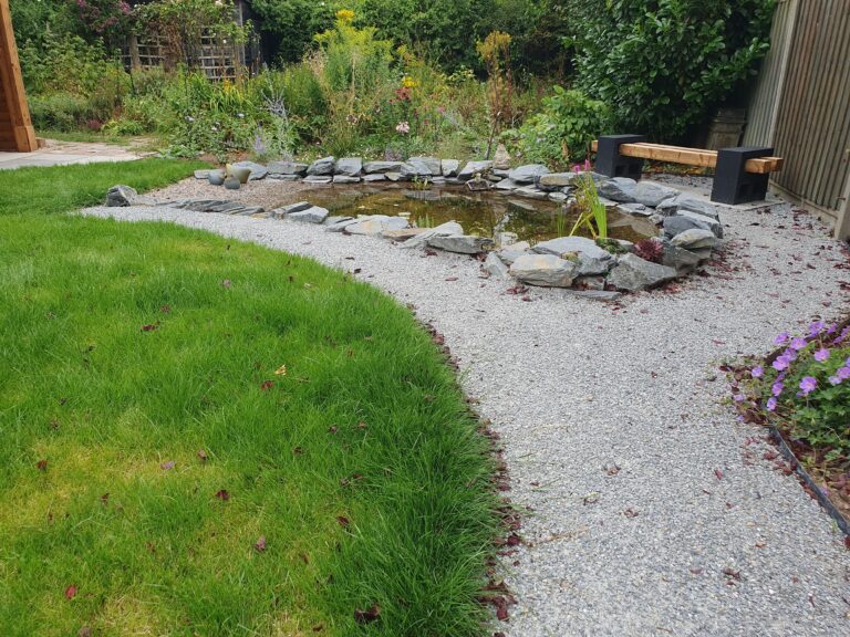 Kate Charles Garden Design – Gazebo Garden – 22 A wildlife pond with a ‘beach’ between a lawn and a planted border, with a stunning wooden bench.